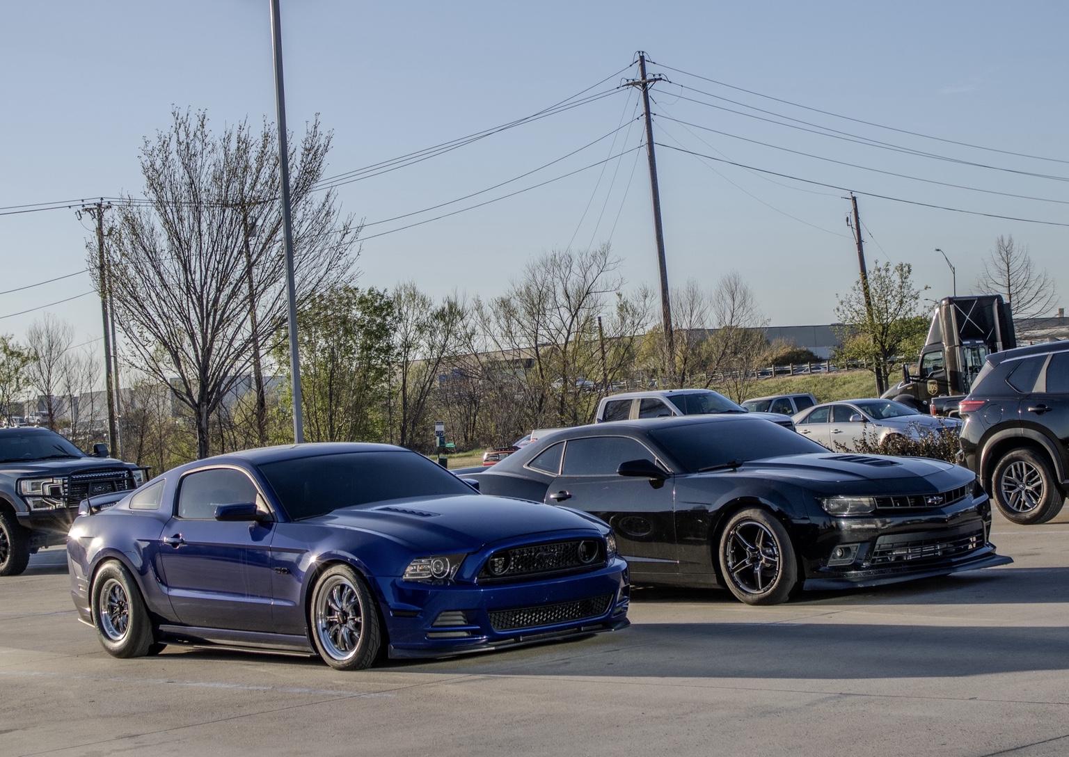 Blue Mustang and black Chevrolet Camaro parked together