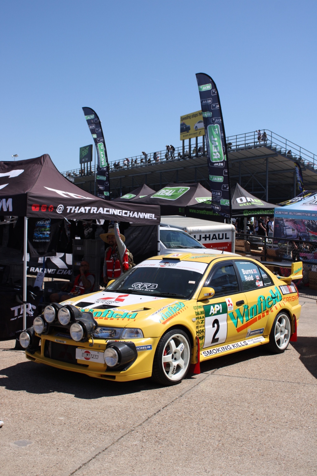 Yellow rally-style Mitsubishi at a car event